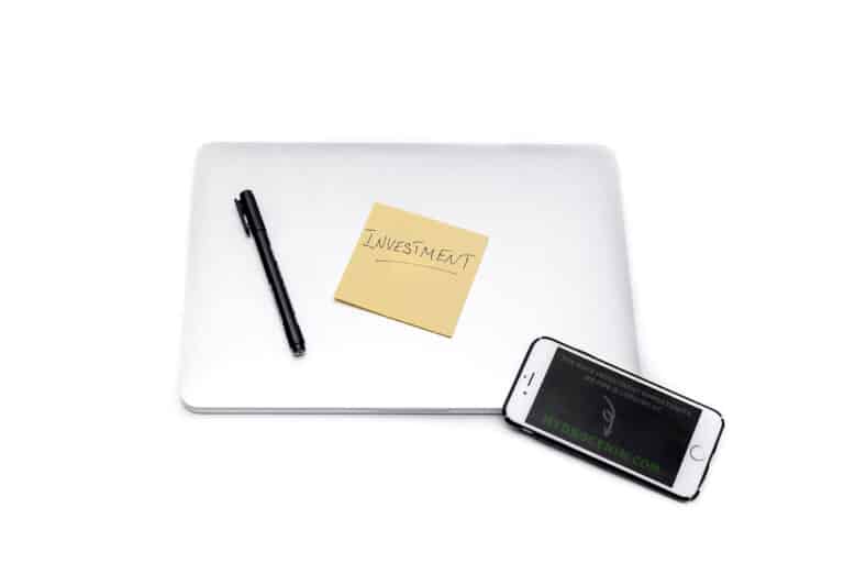 A laptop and smartphone on a desk, set up for comparing vacation rental prices online