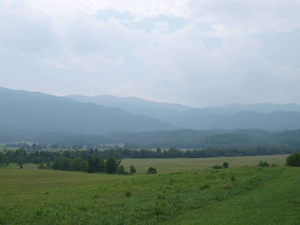 Open meadow and split-rail fencing in Cades Cove with the Great Smoky Mountains rising behind