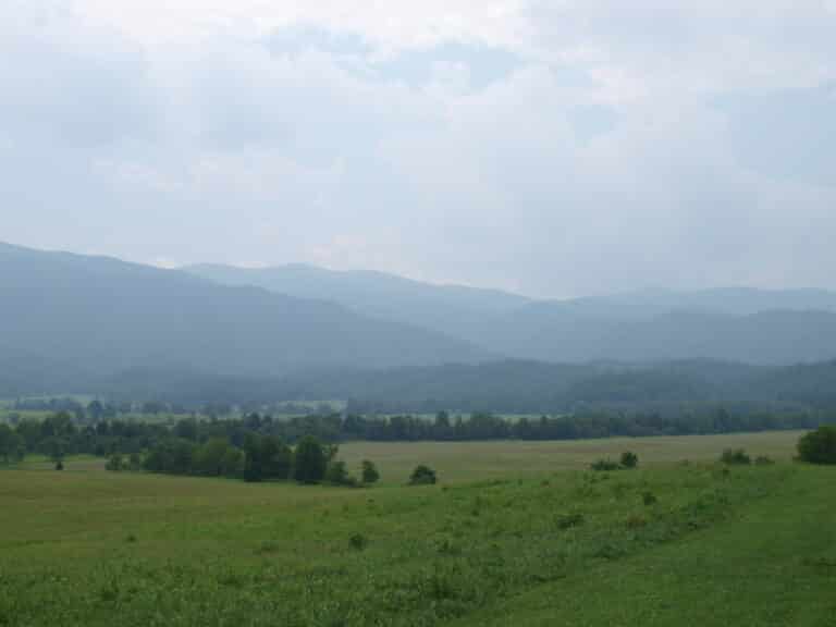 Open meadow and split-rail fencing in Cades Cove with the Great Smoky Mountains rising behind